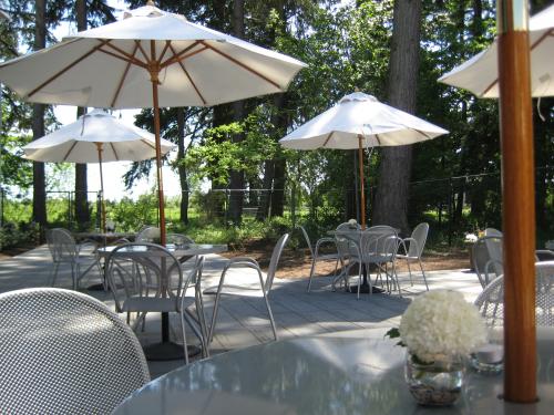 Groups of round, outdoor tables and chairs with white sun umbrellas.
