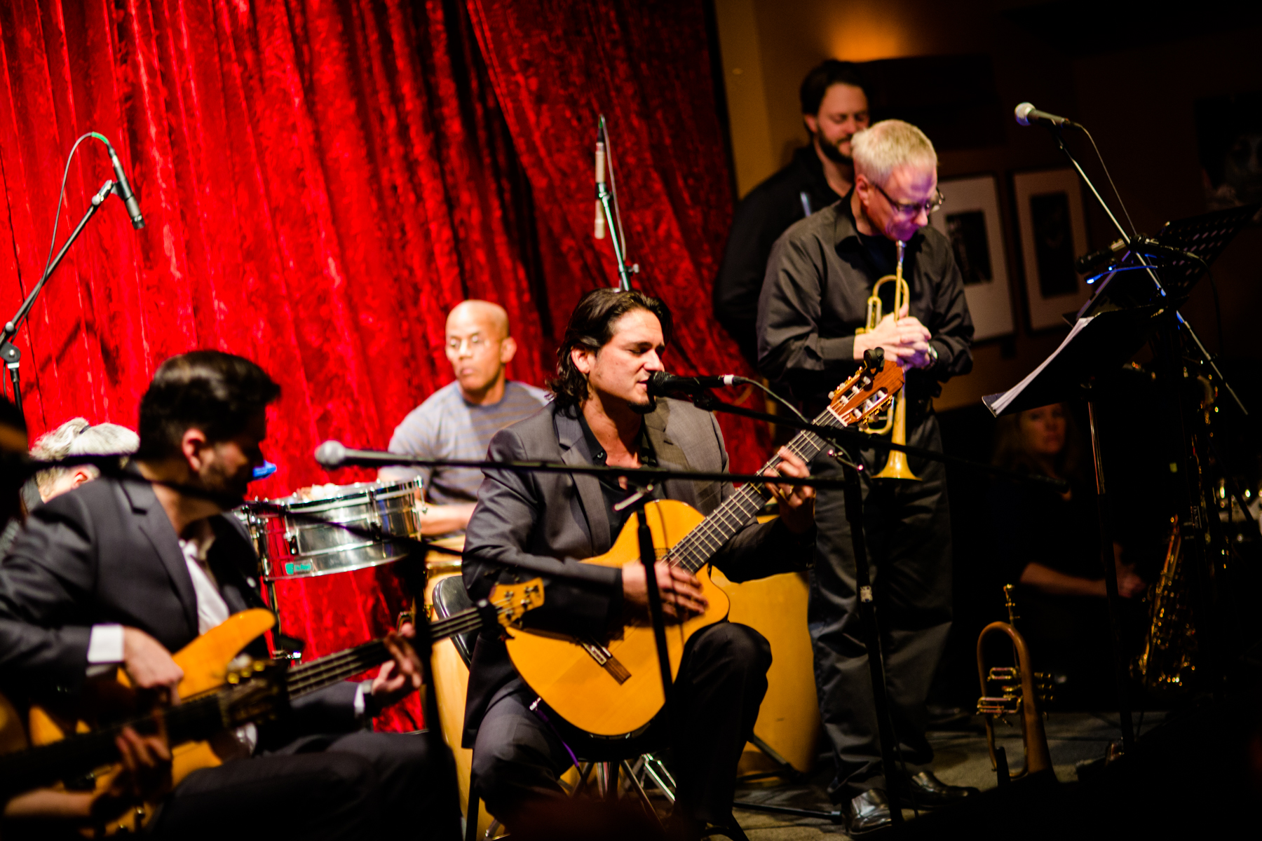 Latin, funk band, Sabrosa, plays music in front of a red curtain