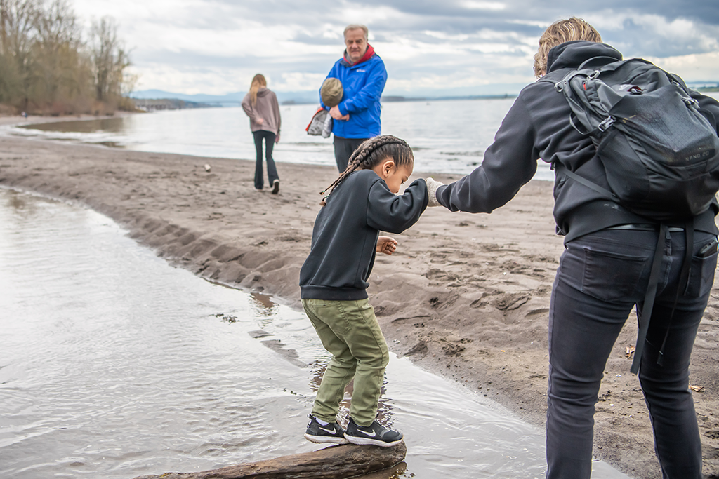 Educator Ashley guides a young visitor along the Columbia River