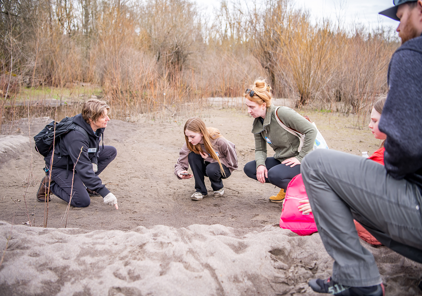 Educator Ashley shows Water Center participants beaver tracks and drag line