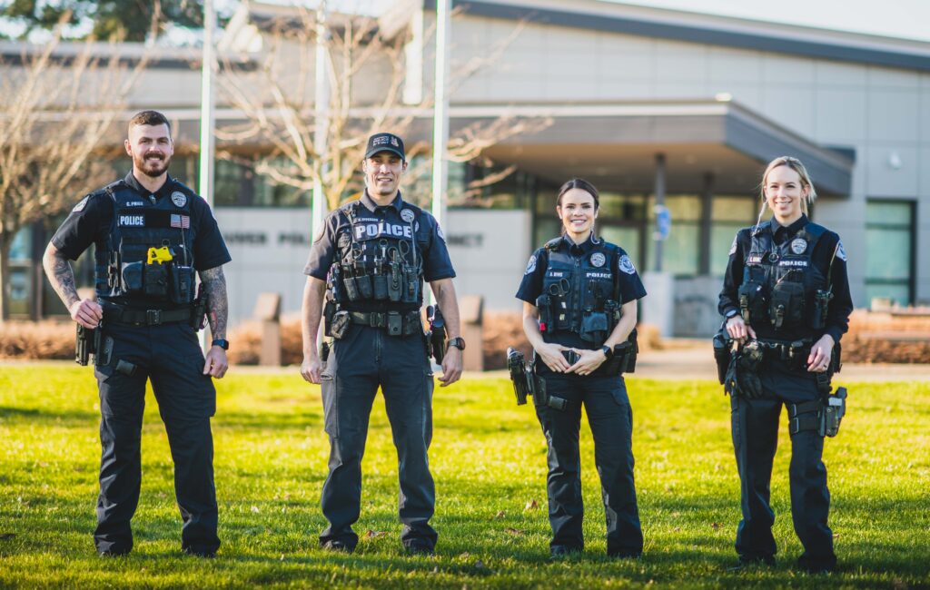 Four police officers standing in front of the east Vancouver police precinct