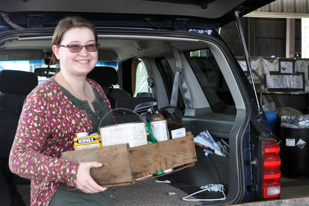 Woman is recycling beyond the curb at home by taking items to a local drop-off site