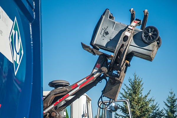 Robotic arm lifts garbage cart up