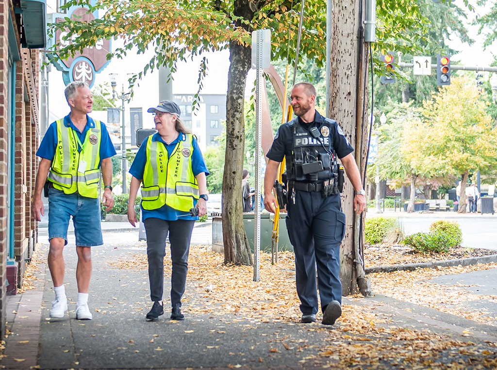 Neighborhood police officer walking with police volunteers in downtown Vancouver