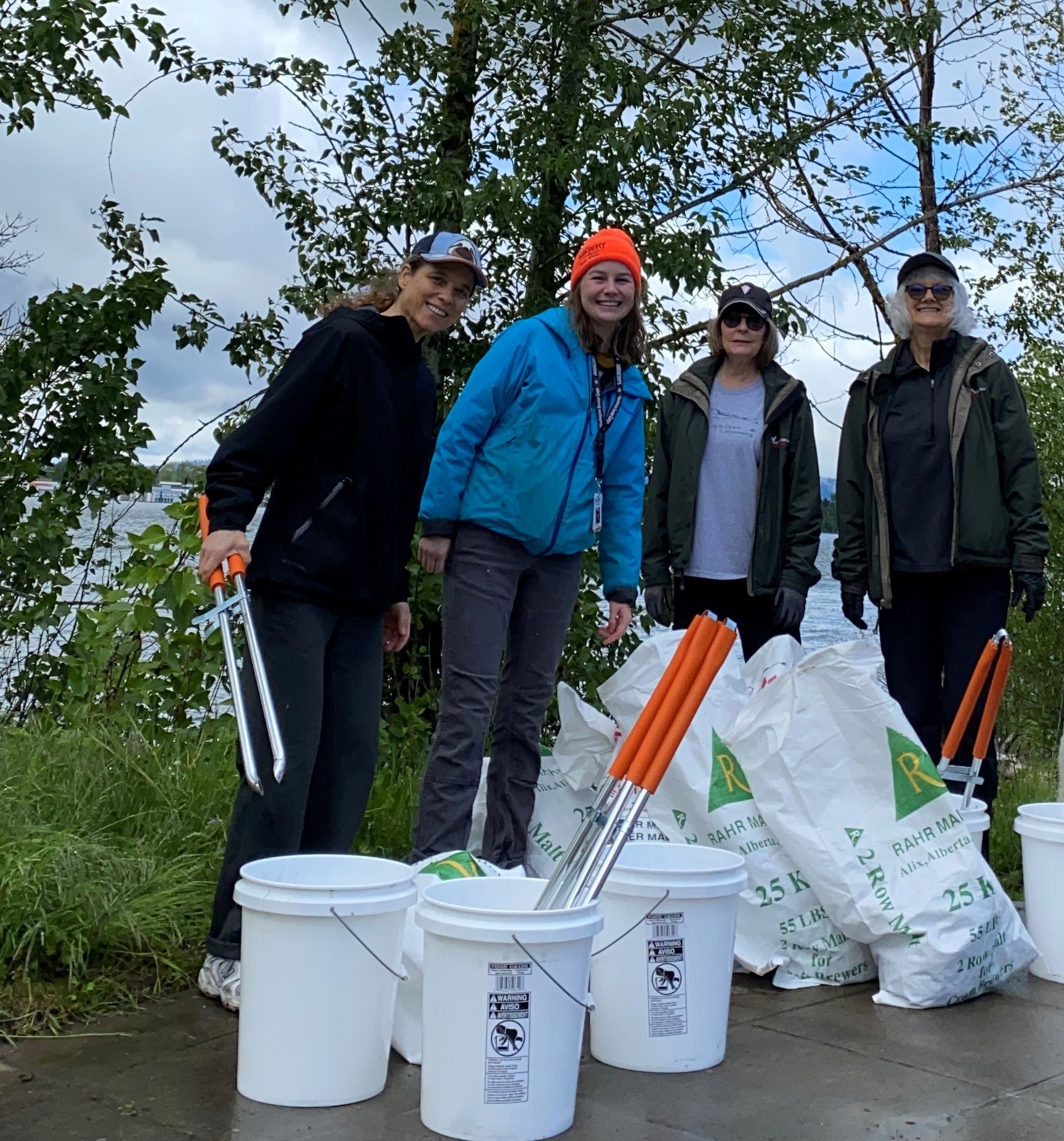 A group of volunteers with litter pickup equipment help clean help remove trash from the beach