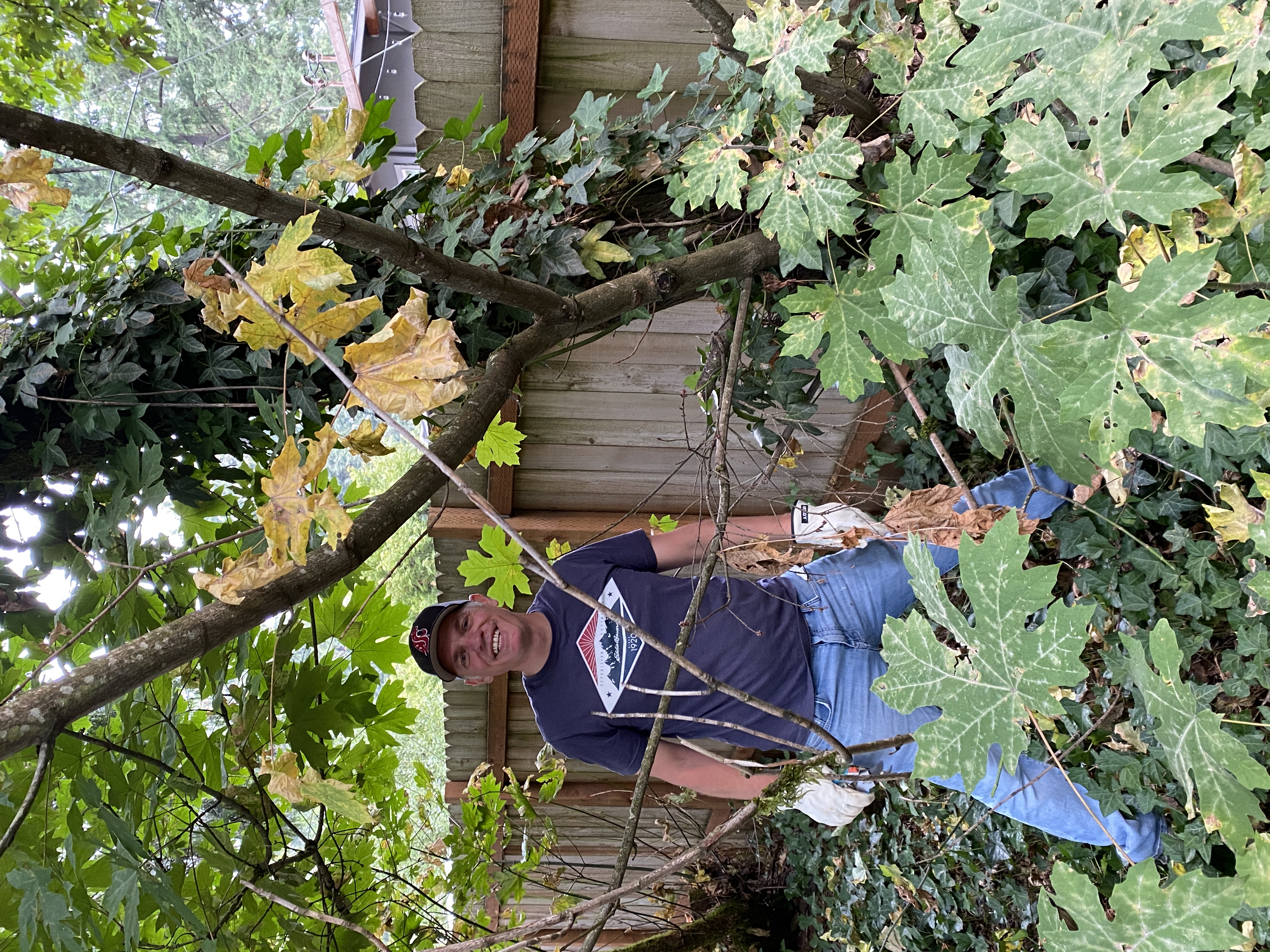 volunteer poses near tree with ivy