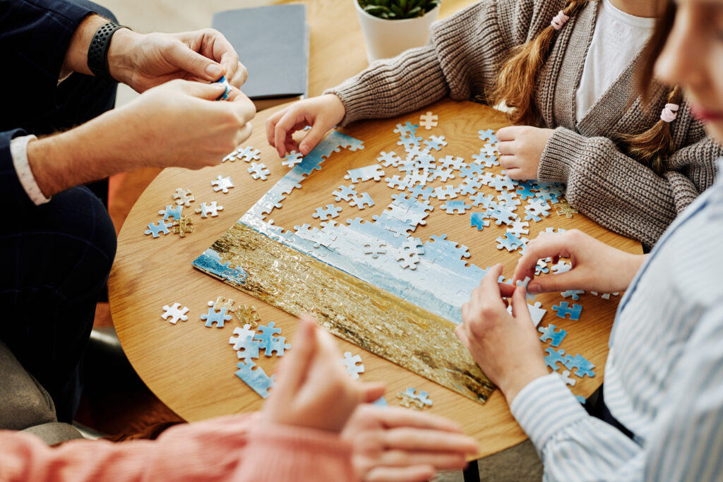 Close up of family playing jigsaw puzzle game together