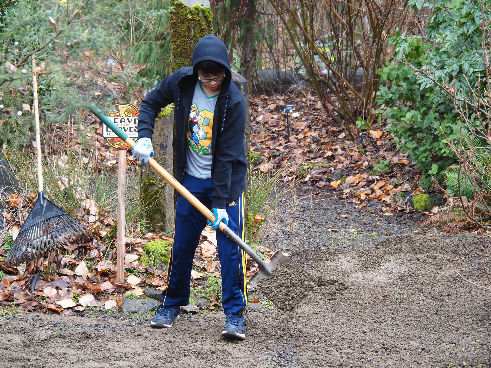 Volunteer spreading gravel on a pathway