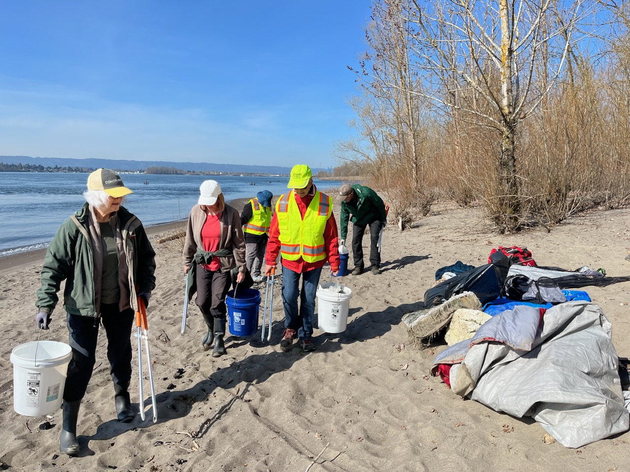 Volunteers helping to clean up the beach and showing litter found along the shoreline