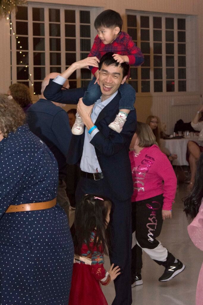 adult dancing with child on shoulders