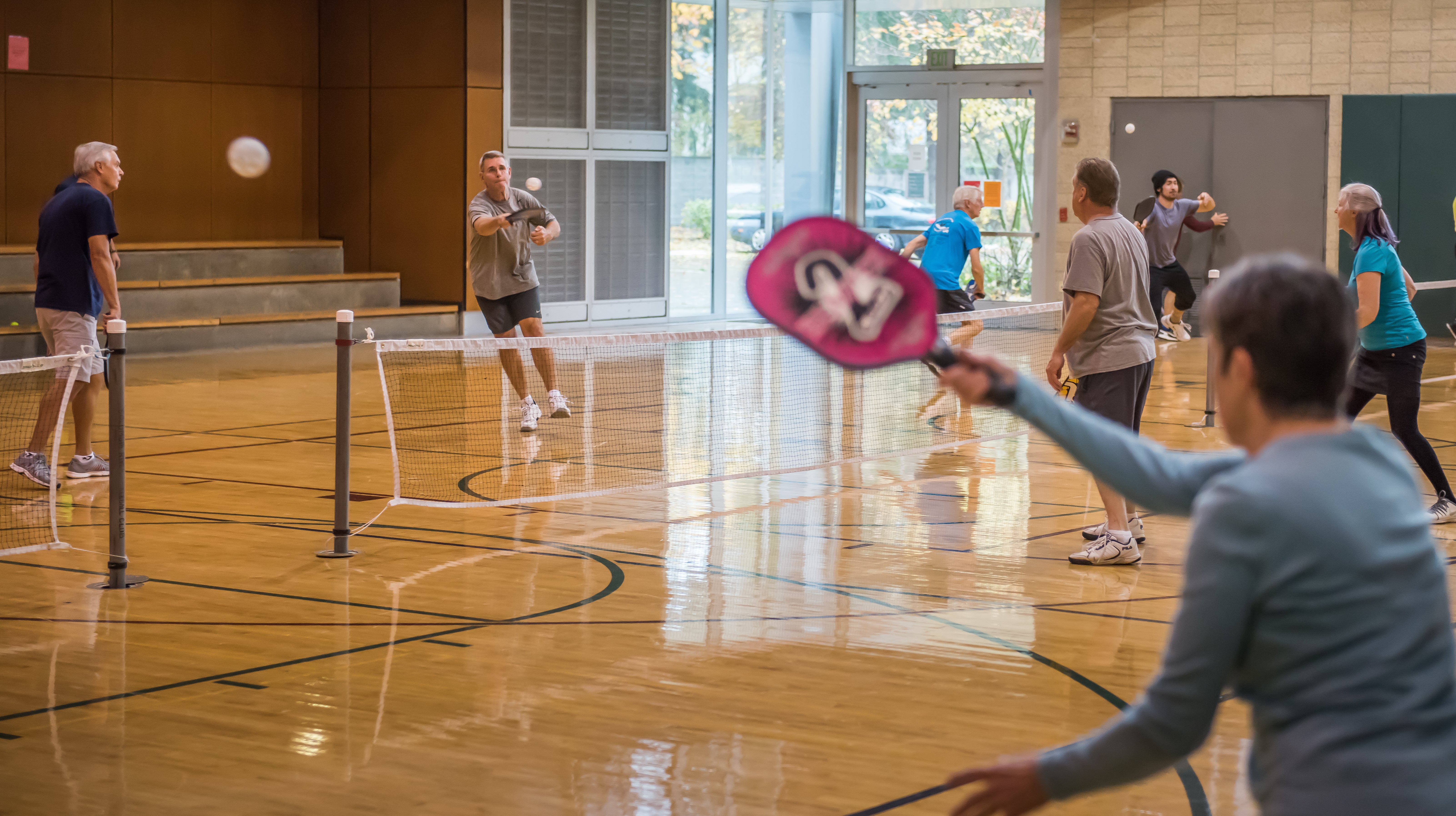 Adults playing pickleball in the Firstenburg gymnasium